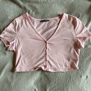 From SHEIN. Baby pink crop top with button in front.